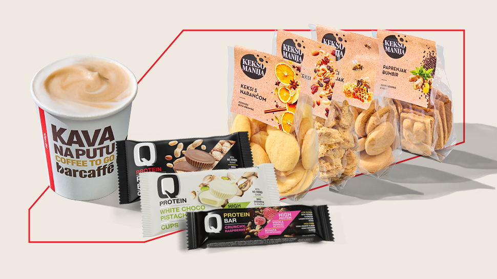 Na slici je kava Kava na poti u čaši za van te izbor keksa i proteinskih čokoladnih pločica.